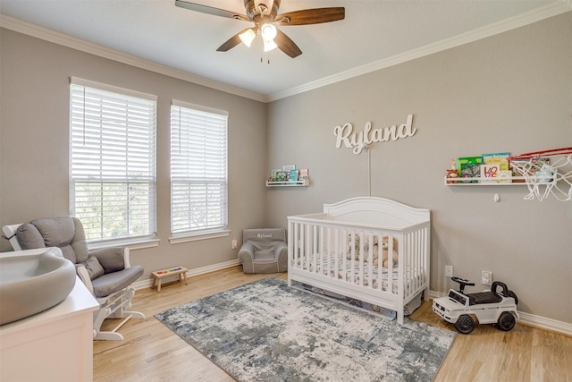 bedroom featuring wood-type flooring, a nursery area, and multiple windows