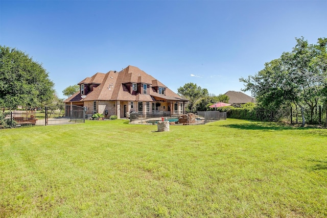 rear view of property featuring a patio and a yard