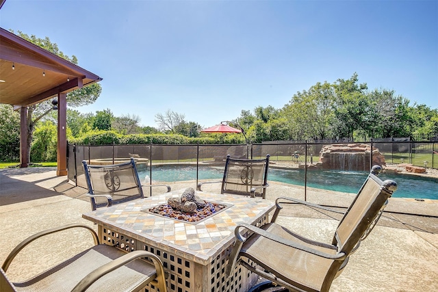 view of swimming pool featuring a fire pit, a patio, and pool water feature