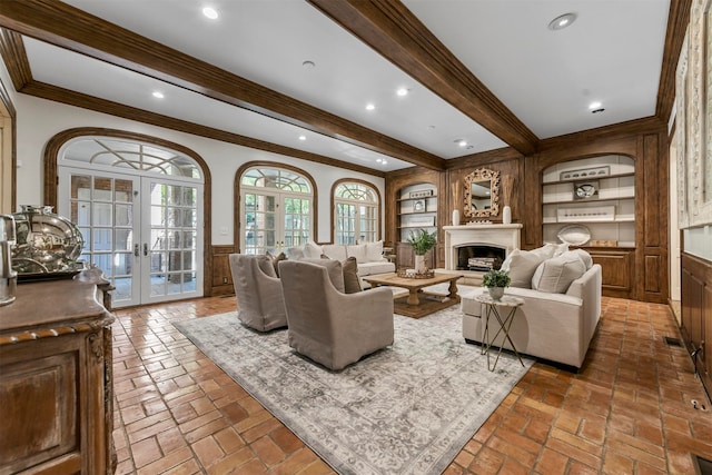 living room with crown molding, beamed ceiling, and french doors