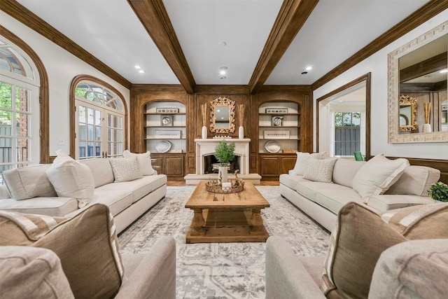 living room with built in shelves, ornamental molding, beamed ceiling, and a healthy amount of sunlight