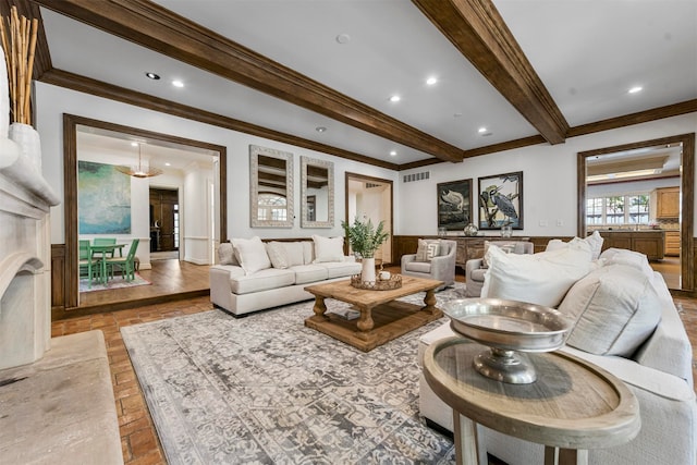 living room with crown molding, a high end fireplace, and beam ceiling