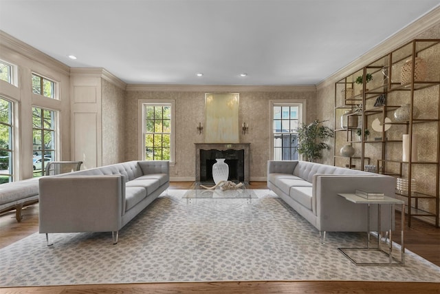 living room featuring a wealth of natural light, crown molding, and light hardwood / wood-style floors