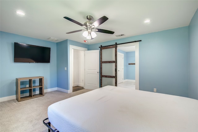 carpeted bedroom featuring ceiling fan and a barn door