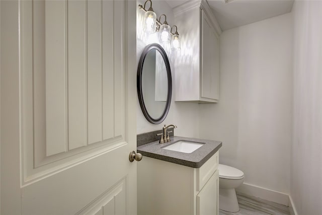 bathroom featuring vanity, wood-type flooring, and toilet