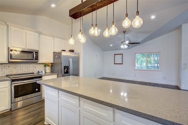 kitchen with vaulted ceiling, light stone counters, stainless steel appliances, and white cabinetry