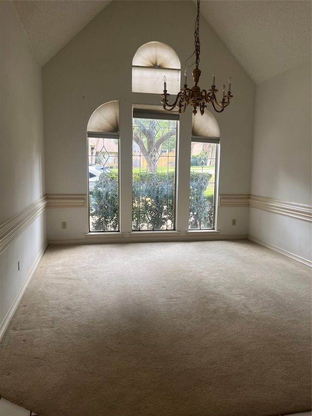 unfurnished room featuring carpet floors, high vaulted ceiling, and a notable chandelier