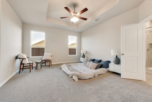 bedroom with carpet flooring, a tray ceiling, and ceiling fan