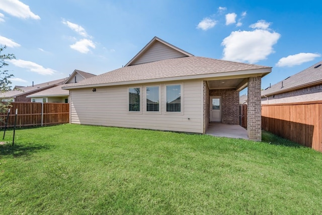 rear view of property with a yard and a patio area