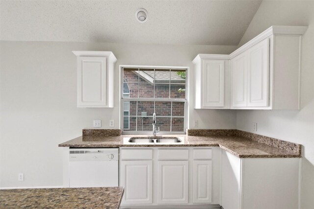 kitchen featuring dishwasher, vaulted ceiling, white cabinetry, and sink