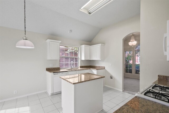 kitchen with lofted ceiling, dishwasher, plenty of natural light, and white cabinets