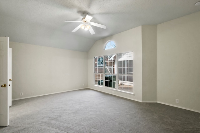 carpeted empty room with ceiling fan, a textured ceiling, and vaulted ceiling