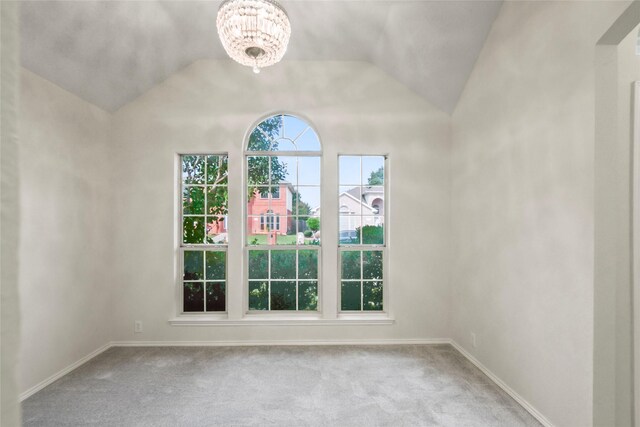 empty room with an inviting chandelier, light carpet, and vaulted ceiling