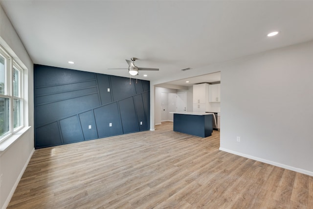 unfurnished living room with ceiling fan and light hardwood / wood-style flooring