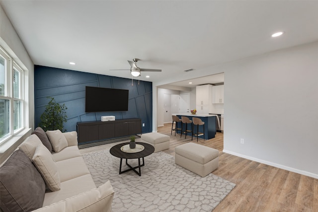 living room with light hardwood / wood-style floors and ceiling fan