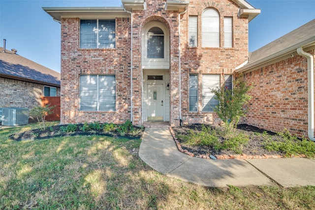 front of property with cooling unit and a front lawn