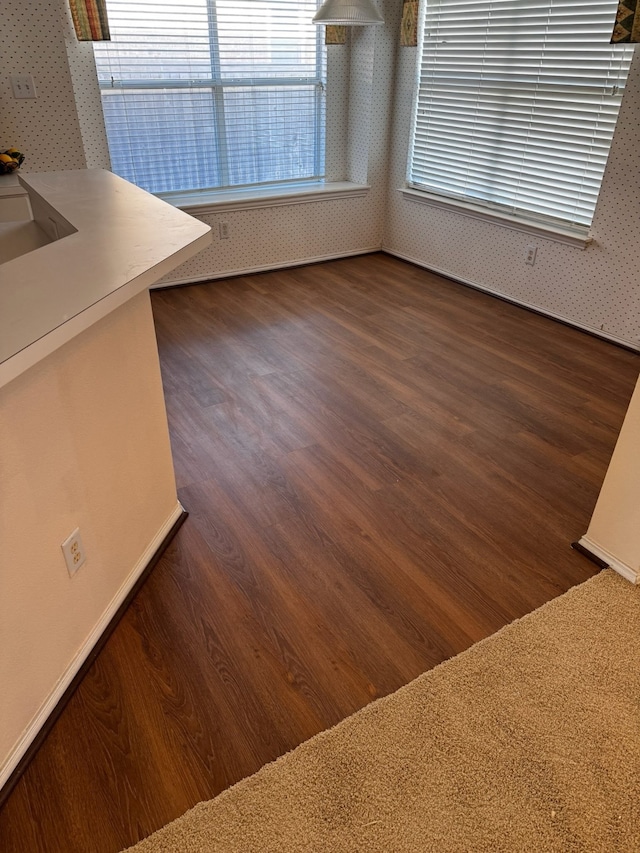 unfurnished dining area featuring dark wood-type flooring