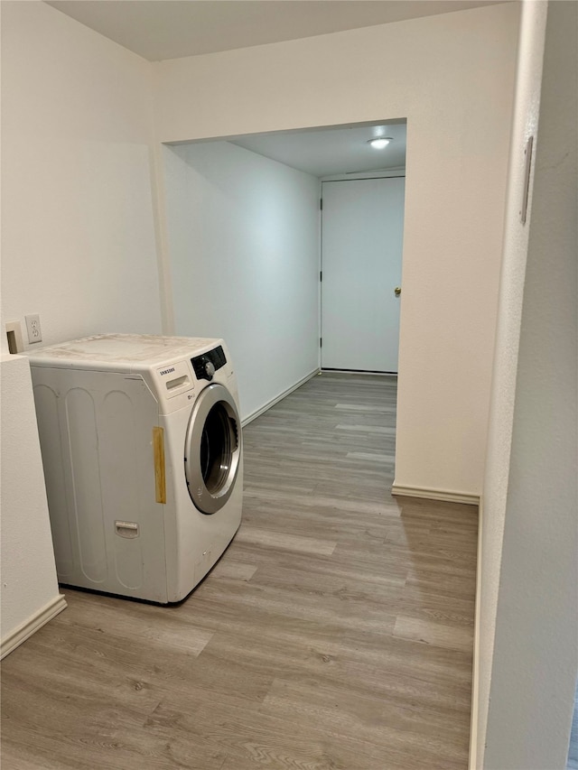 laundry room featuring washer / clothes dryer and light wood-type flooring