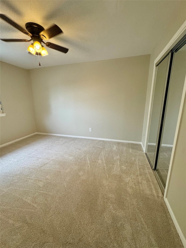 unfurnished bedroom with a closet, ceiling fan, light colored carpet, and a textured ceiling