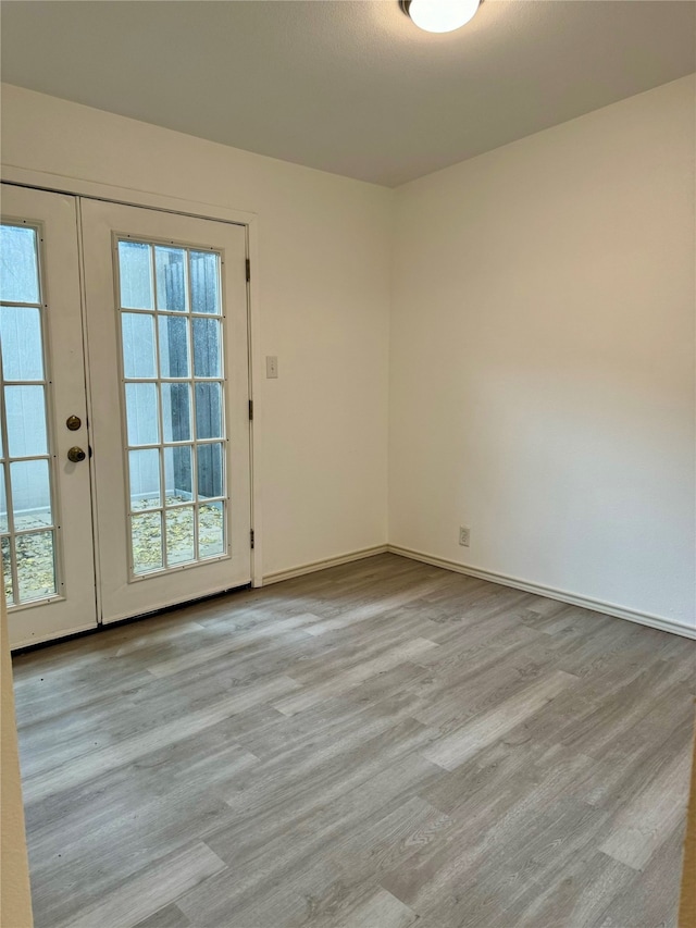 unfurnished room featuring light hardwood / wood-style flooring and french doors