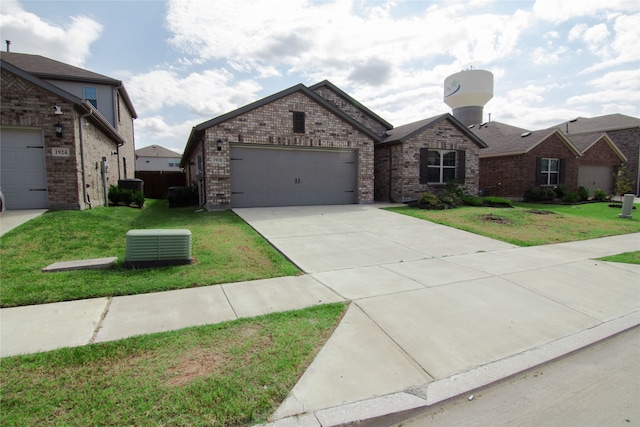 view of front of house with a front lawn, central AC unit, and a garage