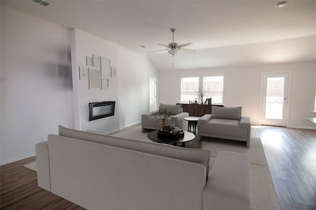 living room featuring wood-type flooring, lofted ceiling, and ceiling fan