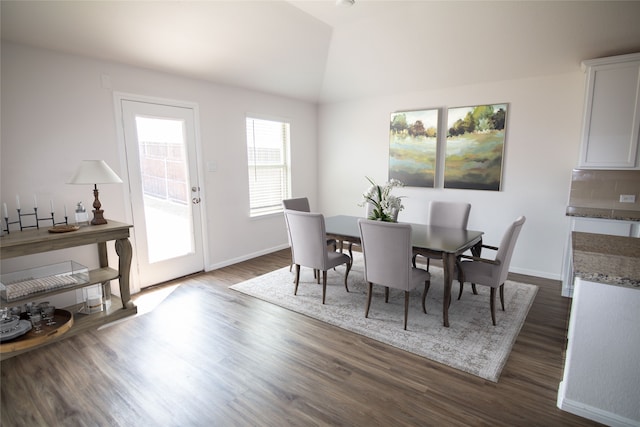 dining area featuring lofted ceiling and dark hardwood / wood-style flooring