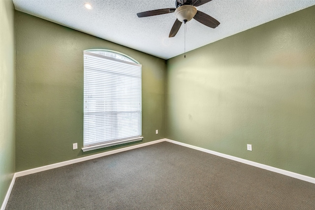 carpeted empty room with a textured ceiling, a healthy amount of sunlight, and ceiling fan