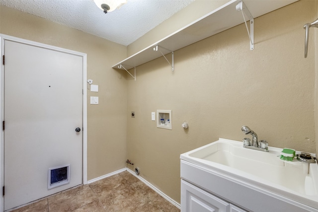 laundry area featuring a textured ceiling, gas dryer hookup, sink, electric dryer hookup, and washer hookup