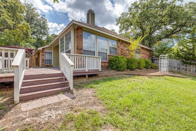 back of property featuring a yard and a deck