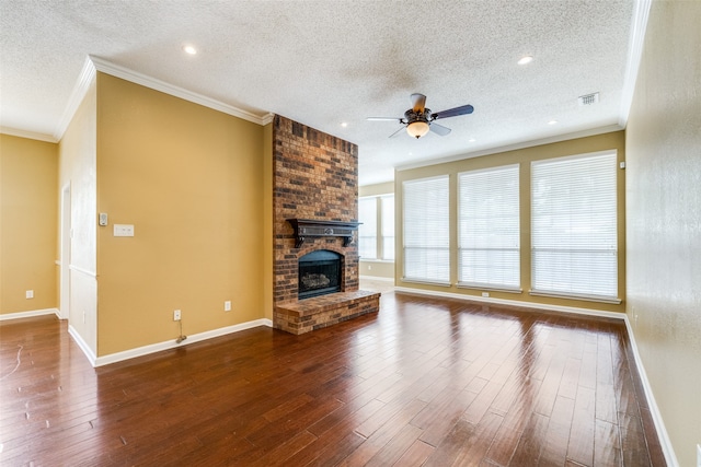 unfurnished living room featuring ceiling fan, dark hardwood / wood-style floors, a textured ceiling, and a brick fireplace