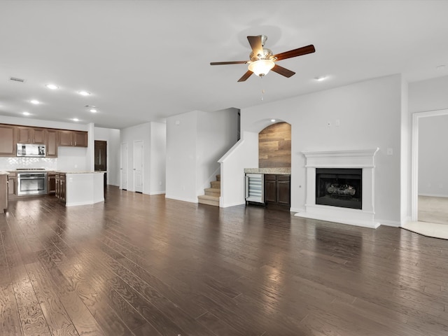 unfurnished living room with ceiling fan and dark hardwood / wood-style flooring