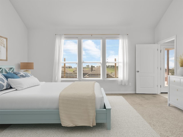 bedroom featuring lofted ceiling and light colored carpet