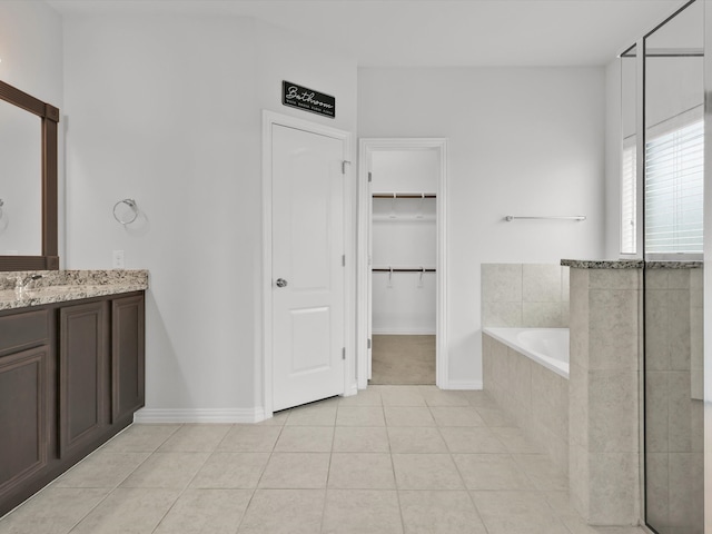 bathroom featuring tile patterned floors, tiled tub, and vanity