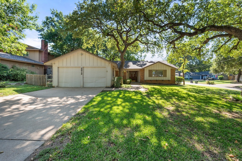 ranch-style house featuring a garage and a front yard