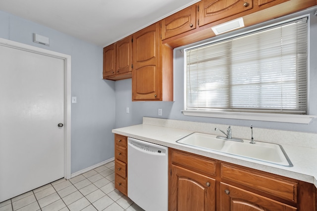 kitchen featuring white dishwasher, sink, and light tile patterned flooring