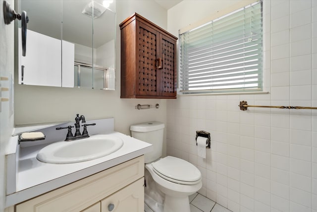 bathroom with tile patterned flooring, toilet, an enclosed shower, tile walls, and vanity