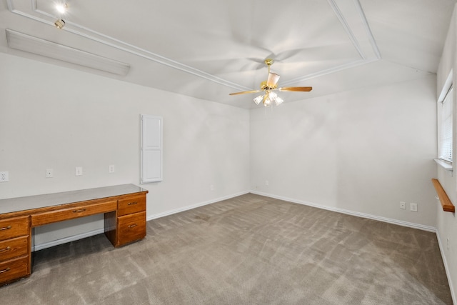 carpeted spare room featuring ceiling fan, built in desk, and vaulted ceiling