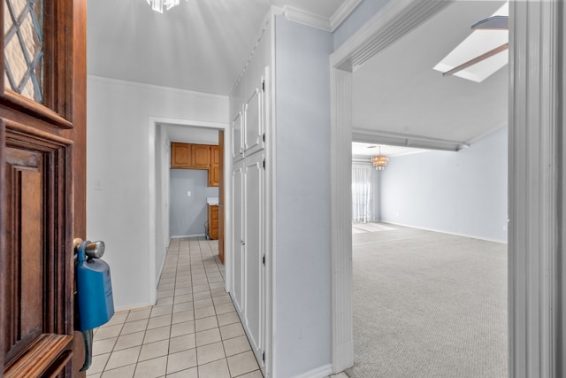 hall featuring ornamental molding, a skylight, and light colored carpet