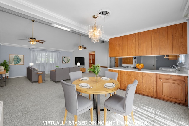 dining space with ceiling fan with notable chandelier, sink, ornamental molding, and light carpet