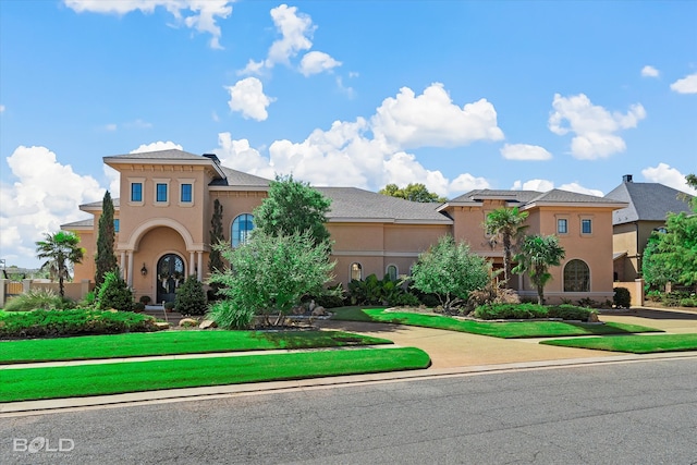 mediterranean / spanish home with a front yard