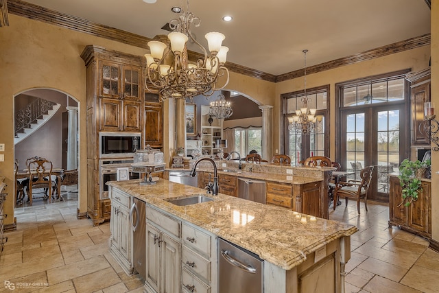 kitchen with pendant lighting, sink, appliances with stainless steel finishes, a notable chandelier, and crown molding