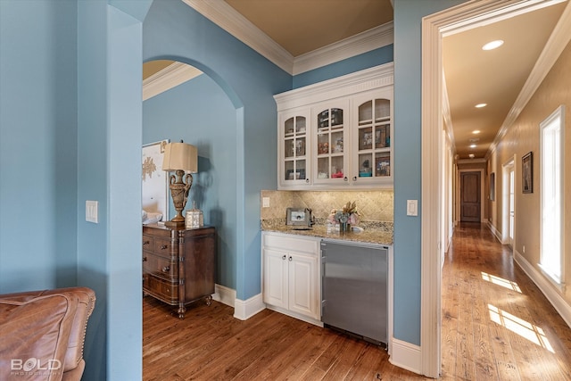 sitting room featuring ceiling fan, beamed ceiling, ornamental molding, built in desk, and light hardwood / wood-style floors