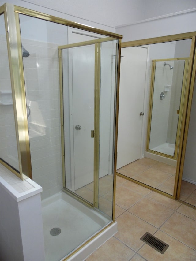 bathroom featuring a shower with door and tile patterned flooring