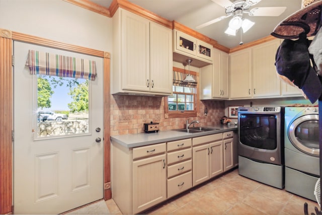 clothes washing area with cabinets, light tile patterned floors, ceiling fan, sink, and washer and clothes dryer