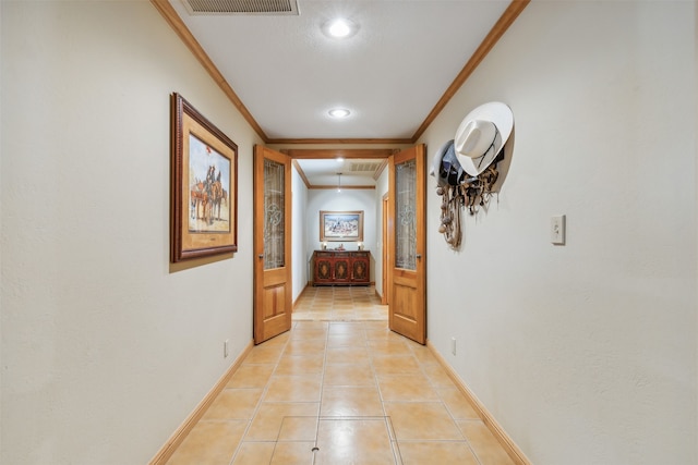 hallway with crown molding and light tile patterned floors