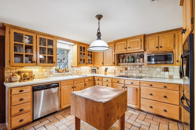 kitchen featuring stainless steel appliances, tasteful backsplash, a center island, and decorative light fixtures