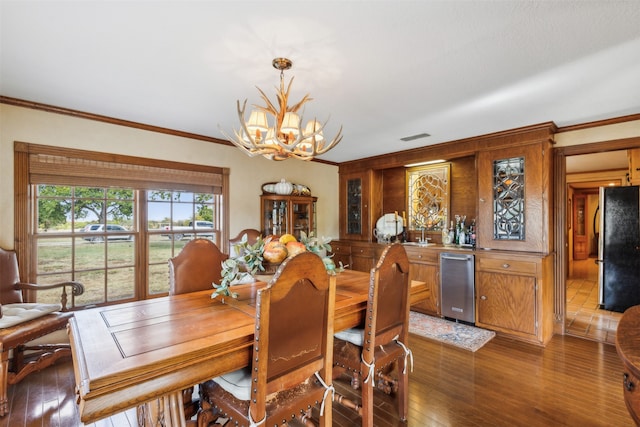 dining area with crown molding, dark hardwood / wood-style flooring, and an inviting chandelier