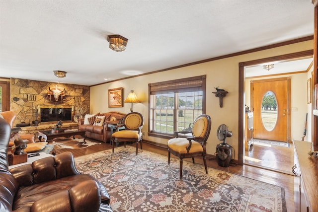 living room with a stone fireplace, crown molding, and wood-type flooring