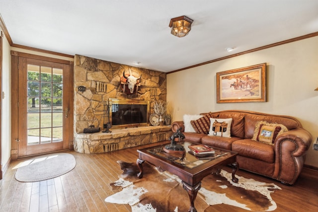 living room with ornamental molding, a fireplace, and hardwood / wood-style flooring